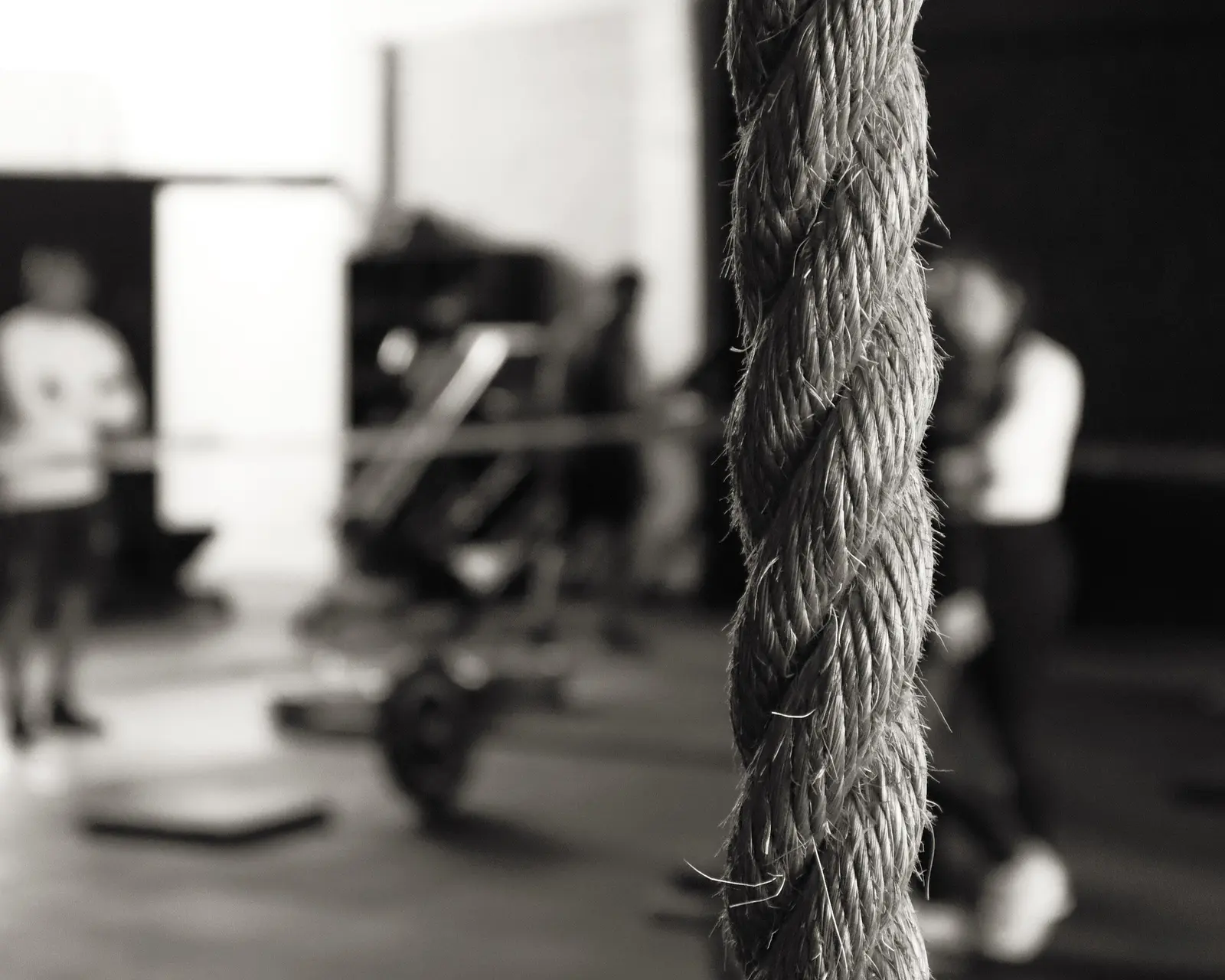 The climbing rope in the foreground, training behind it, in black and white